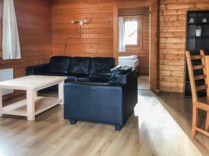 ein Wohnzimmer mit einem schwarzen Ledersofa und einem Tisch in der Unterkunft Holiday Home De Brenkberg-1 in Schinveld