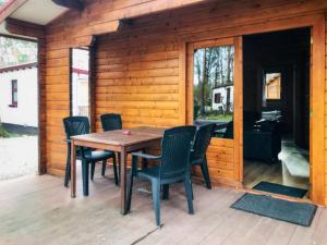 een houten tafel en stoelen op het terras van een hut bij Holiday Home De Brenkberg-1 in Schinveld