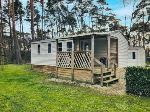 a tiny house with a porch and a deck at Holiday Home De Brenkberg-1 in Schinveld