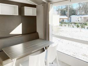 Holiday Home De Brenkberg-1 في Schinveld: غرفة طعام مع طاولة وكراسي ونافذة