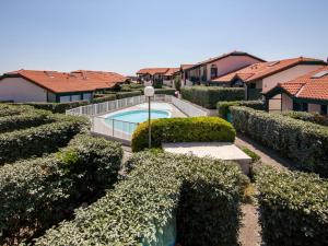a yard with a swimming pool and some bushes at Apartment Maison de l'océan-6 by Interhome in Capbreton