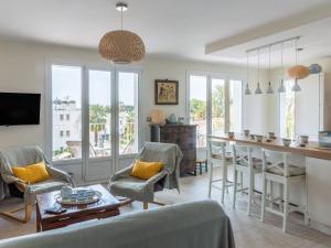 a living room with a kitchen and a bar with chairs at Apartment Les Palmiers by Interhome in Saint-Cyr-sur-Mer