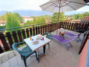 a patio with a table and chairs and an umbrella at Apartment Residenza Agrifoglio-6 by Interhome in Luino
