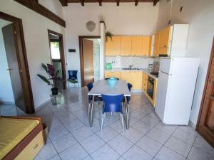 a kitchen with a table and a white refrigerator at Apartment Residenza Agrifoglio-7 by Interhome in Luino