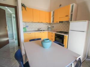 a kitchen with orange cabinets and a table with a vase on it at Apartment Residenza Agrifoglio-7 by Interhome in Luino +28 photos