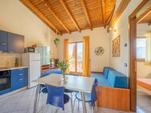 a kitchen with a table and a blue couch at Apartment Residenza Agrifoglio-8 by Interhome in Luino