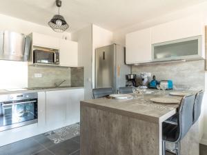 Una cocina con gabinetes blancos y una mesa con sillas. en Apartment Les Portes de Pyla by Interhome, en La Teste-de-Buch 15 fotos más
