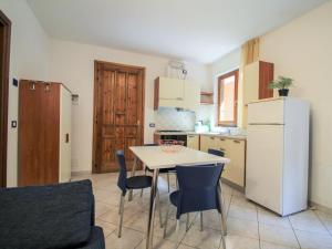 a kitchen with a table and chairs and a refrigerator at Apartment Residenza Agrifoglio-9 by Interhome in Luino
