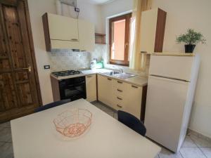 a kitchen with a white refrigerator and a table with chairs at Apartment Residenza Agrifoglio-9 by Interhome in Luino +20 photos
