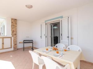 a white dining room with a table and white chairs at Apartment Mari by Interhome in Olbia