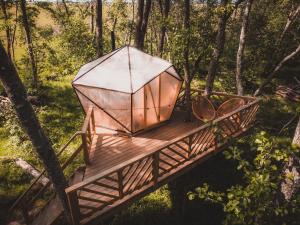 une tente sur un pont en bois dans les bois dans l'établissement Hekso treehouse, 