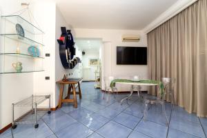 a living room with a table and chairs and a television at Suitesettepesciolini - Casa vacanza PERLA in Salerno