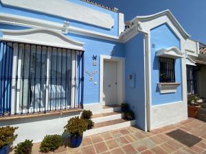 ein blaues Haus mit einem Balkon und einer Tür in der Unterkunft Charming 1 bedroom suite with shared kitchen next to Puerto Banus in Marbella