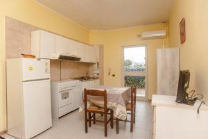 eine Küche mit einem Tisch und einem weißen Kühlschrank in der Unterkunft Villa erica appartamento Alice in Villa San Pietro