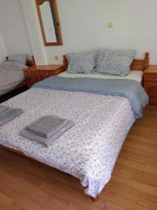 a bedroom with a bed with a blanket and a mirror at Стаи за гости Маги in Sinemorets