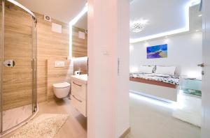 a bathroom with a shower and a toilet and a bed at Casa Aurelia - Mali Tone in Krk