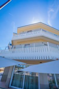 a large building with a balcony and an umbrella at Hotel Baby in Rimini
