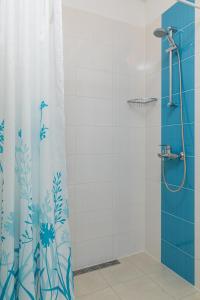 une douche avec rideau de douche bleu et blanc dans l'établissement Apartments Silvija, à Mokošica