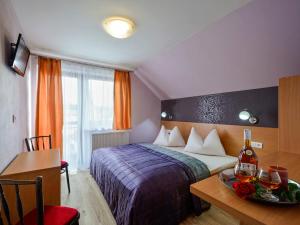 ein Hotelzimmer mit einem Bett, einem Schreibtisch und einem Tisch mit einem Teller in der Unterkunft Ubytovanie pod Tatrami in Nová Lesná