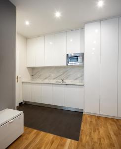 una cucina con armadi bianchi e piano di lavoro di The Levante Rathaus Apartments a Vienna