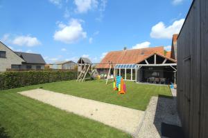 un pequeño patio con un parque infantil con un tobogán en Het Rustplekje, en Alveringem