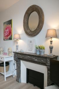 a living room with a fireplace with a mirror at Logis des Halles du Coderc in Périgueux