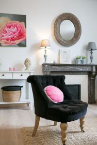 a black chair with a pink pillow in a living room at Logis des Halles du Coderc in Périgueux