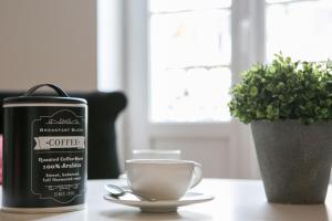 a coffee container sitting on a table next to a cup at Logis des Halles du Coderc in Périgueux