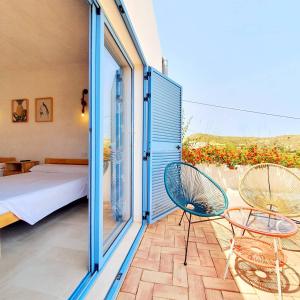 a bedroom with a bed and two chairs on a balcony at B&B La Nava Suites in Mojácar