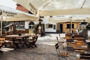 an outdoor patio with tables and chairs and umbrellas at Ferienwohnung Waldgasthaus Armeleuteberg in Wernigerode