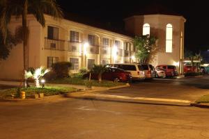 een gebouw met auto's geparkeerd op een parkeerplaats 's nachts bij Ocean Gateway Inn in Santa Paula