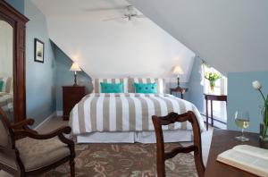 1 dormitorio con 1 cama grande y paredes azules en Brewster House Bed & Breakfast en Freeport