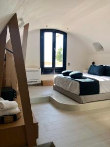 a bedroom with two beds and a large window at Candele Suites in Fira