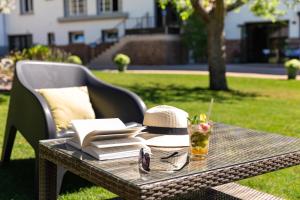 una mesa de picnic con un sombrero y una bebida en ella en Hotel De La Pommeraie, en Le Mans