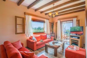 a living room with red couches and a tv at Villa Emilia in Sidari