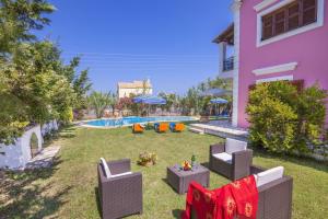a backyard with a pool and chairs and a house at Villa Emilia in Sidari