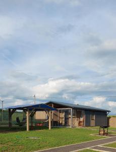 a building with a blue roof and a bench in a field at Нарочанская хатка 3 in Cherevki