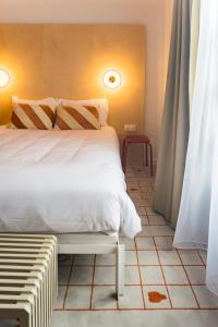 a bedroom with a bed and a bench in it at Hôtel Ô Rouge Gevrey-Chambertin - Teritoria in Gevrey-Chambertin