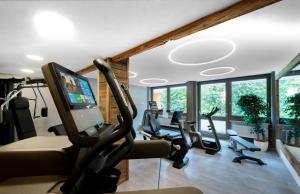 a gym with treadmills and ellipticals in a room with windows at Hotel Fontana in Bad Kissingen