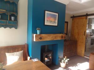 uma sala de estar com uma parede azul e uma lareira em Rowan Cottage em Ottringham