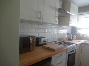 uma cozinha com um micro-ondas e um fogão forno superior em Rowan Cottage em Ottringham