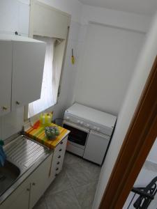 eine kleine Küche mit einer Spüle und einem Herd in der Unterkunft Baciati dal Sole - Appartamento in centro in Porto Empedocle