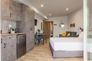 a bedroom with a large bed and a kitchen at Raise Heraklion Boutique Apartments in Heraklio Town