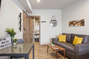 a living room with a couch and a table at Raise Heraklion Boutique Apartments in Heraklio Town