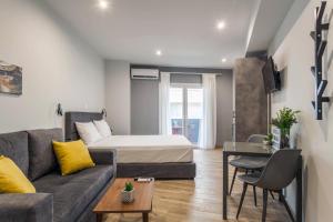 a living room with a couch and a bed at Raise Heraklion Boutique Apartments in Heraklio Town