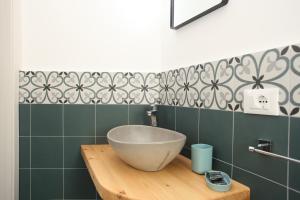 a bathroom with a bowl sink on a wooden counter at Casa Maja rooms & suites in Favignana