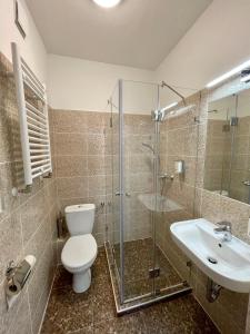 a bathroom with a toilet and a shower and a sink at Thomas Hotel Budapest in Budapest