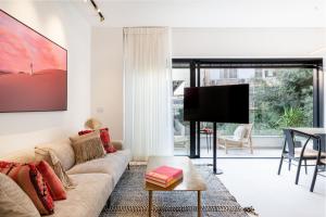 sala de estar con sofá y TV de pantalla plana en Beachfront Diamond by Five Stay, en Tel Aviv