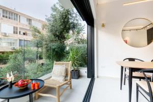 Habitación con ventana grande, mesa y sillas. en Beachfront Diamond by Five Stay, en Tel Aviv