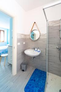 uma casa de banho com um lavatório, um espelho e um chuveiro em Aloha em San Benedetto del Tronto